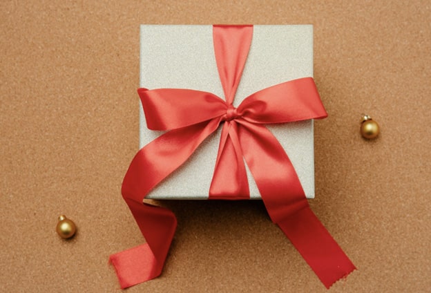 A box with a red bow on against a brown backdrop