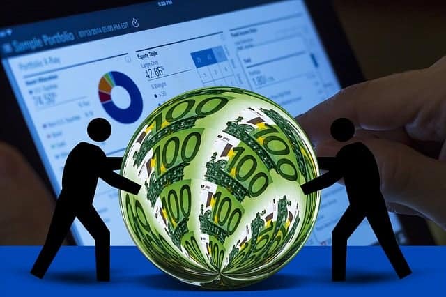 Euro currency with silhouette figures in front of laptop screen