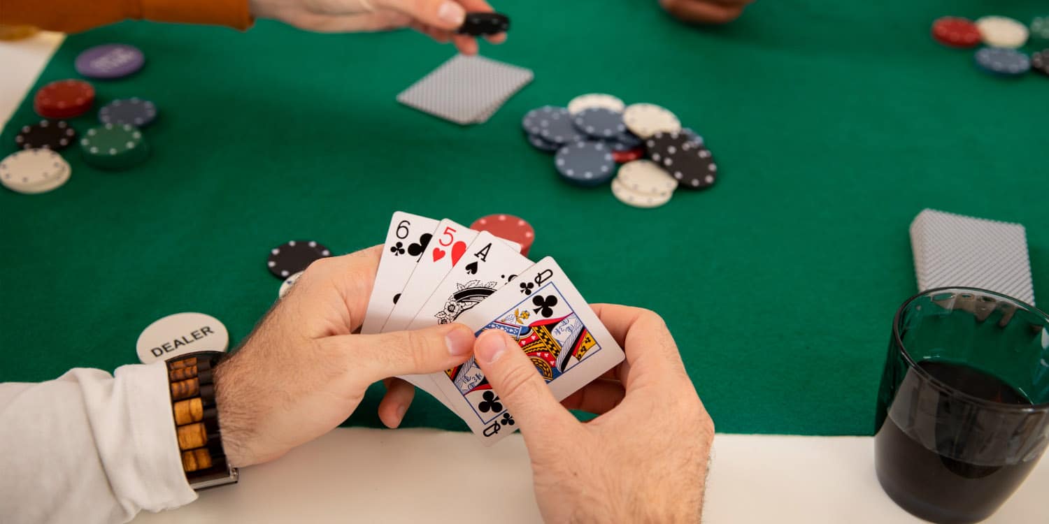 Online Poker hands with poker chips and drinks